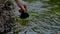 Hiker filling a cup with water from the river in slow motion