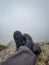 Hiker foot resting at mountain top from flat angle at morning