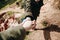 A hiker gives a hand to another person during hiking in a mountainous area.