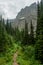 Hiker Heads Down Trail Toward Morning Eagle Falls With Bishops Cap Looming Overhead