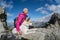 Hiker and her dog on a rocky mountain top