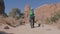 Hiker Hiking With Backpack Among Orange Rock Massifs In Arches National Park