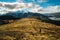 A hiker hiking on the beautiful track with a landscape of the mountains and Lake Wanaka. Roys Peak Track, South Island, New