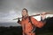 Hiker Holding Stick Across Shoulders On Hillside