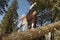 Hiker Jumping Over Fallen Tree In Forest