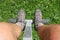 Hiker legs and shoes on a mountain chair lift in summer season