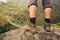 Hiker legs standing on rock above mountain suspension bridge