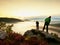 Hiker look down into fogy valley. Photographer stay on cliff and takes photos.