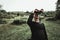 Hiker looking through binoculars in front of hills and mountain range. Prevalla, Prizren, Kosovo