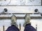 Hiker looking down at boots on stairs in snow with poles