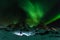 Hiker in the magical northern lights in Lofoten Islands, Norway. Aurora borealis