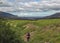 Hiker man alone into the wild admiring volcanic landscape of green Icelandic valley. Laugavegur hiking trail, summer vacations