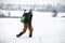 Hiker - man with backpack walking on snowy field