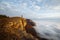 Hiker man cheering with arms spread and raised to the sky after hiking mountain top summit. Climber with backpack on the