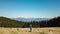 Hiker man on golden alpine meadow of mount Hochanger in Bruck an der Mur, Lavanttal Alps, Styria, Austria. Idyllic forest