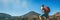 Hiker man hiking in banner landscape Tongariro National Park Alpine crossing hike trail man tramper tramping panoramic