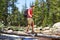 Hiker man hiking crossing river in Yosemite