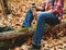 Hiker man holding thermos and cup of tea in forest