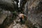 Hiker man in mountains. tourist with a backpack climbs a rock