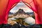 Hiker man relaxing in a tent with mount assiniboine view in autumn forest