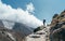 Hiker man silhouette on clouds background standing on path going over the Imja Khola valley and enjoying mountain views during an