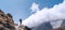 Hiker man silhouette on clouds background standing on path going over the Imja Khola valley and enjoying mountain views during an