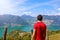 Hiker man standing admiring a mountaintop view looking out over distant ranges of mountains and valleys in a healthy