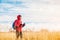 Hiker man standing in the field and looking at scenic field landscape