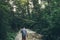 Hiker Man Walks Along Mouth Of Mountain River In Deep Forest, Rear View. Trek Hiking Destination Experience Lifestyle Concept