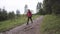 Hiker man wearing hiking backpack and red jacket while walking in summer forest. Stock footage. Young man following the