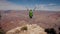 Hiker Mature Woman Walks To Edge Of Grand Canyon Rocks And Raises Her Arms Up