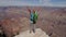 Hiker Mature Woman Walks To Edge Of Grand Canyon Rocks And Raises Her Arms Up
