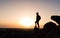 Hiker on the mountain top facing the sunset