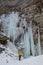 Hiker near frozen Awosting Falls, massive icicles hang from the cliffs in Minnewaska State Park in Upstate New York. USA