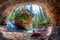 Hiker outside his camping tent at Hidden Cave with waterfall and limestone bedrock in Johnston Canyon at Banff National Park