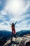 Hiker outstretched arms stand at cliff edge on mountain top