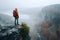 Hiker Overlooking Misty Canyon at Sunrise