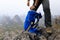 Hiker packing the backpack on mountain top cliff edge