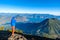 Hiker with panorama view of Lake Atitlan and volcano San Pedro and Toliman early in the morning from peak of volcano Atitlan,