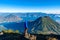 Hiker with panorama view of Lake Atitlan and volcano San Pedro and Toliman early in the morning from peak of volcano Atitlan,