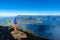 Hiker with panorama view of Lake Atitlan and volcano San Pedro and Toliman early in the morning from peak of volcano Atitlan,