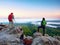 Hiker and photographer stay with tripod on cliff and takes photos. Autumn windy landscape,