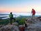 Hiker and photographer stay with tripod on cliff and takes photos. Autumn windy landscape,