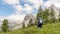 Hiker photographs while taking a shot of a mountain range in the Dolomites