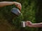 Hiker pouring a hot drink from a metal teapot into a steel mug