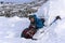 Hiker pours himself a hot drink from a thermos, sitting in a snowy house igloo