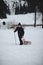 Hiker pulls to the top of a wooden sled for a ride on the piste. Going back to childhood. Candid portrait of a man pulling a