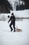 Hiker pulls to the top of a wooden sled for a ride on the piste. Going back to childhood. Candid portrait of a man pulling a