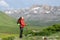 Hiker in red resting and breathing fresh air in the mountain