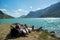 hiker resting on backpack and taking photo of Gjende lake in Jotunheimen National